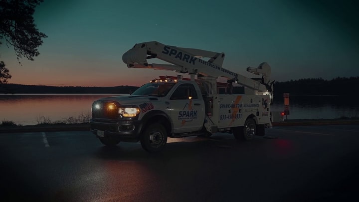 Video production of bucket truck in front of lake during sunrise