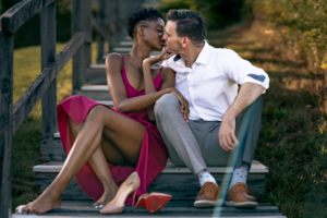 Woman kissing man on stairs with shoes off