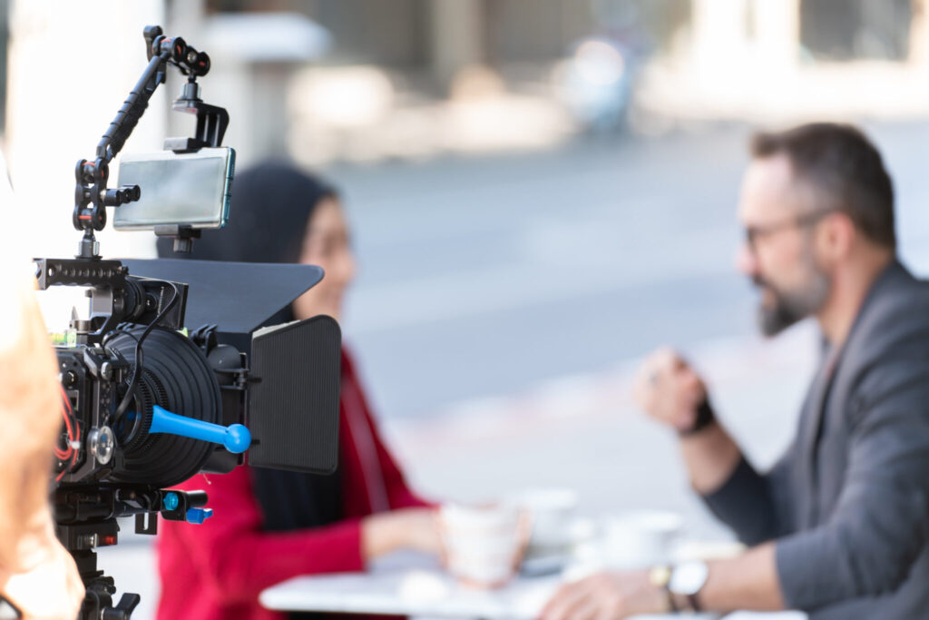 Reporter interviewing Success businessman With Video Camera at Cafe. top video production companies video production company video production services lifi media production