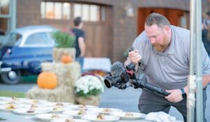 Videographer with camera filming a live dinner event