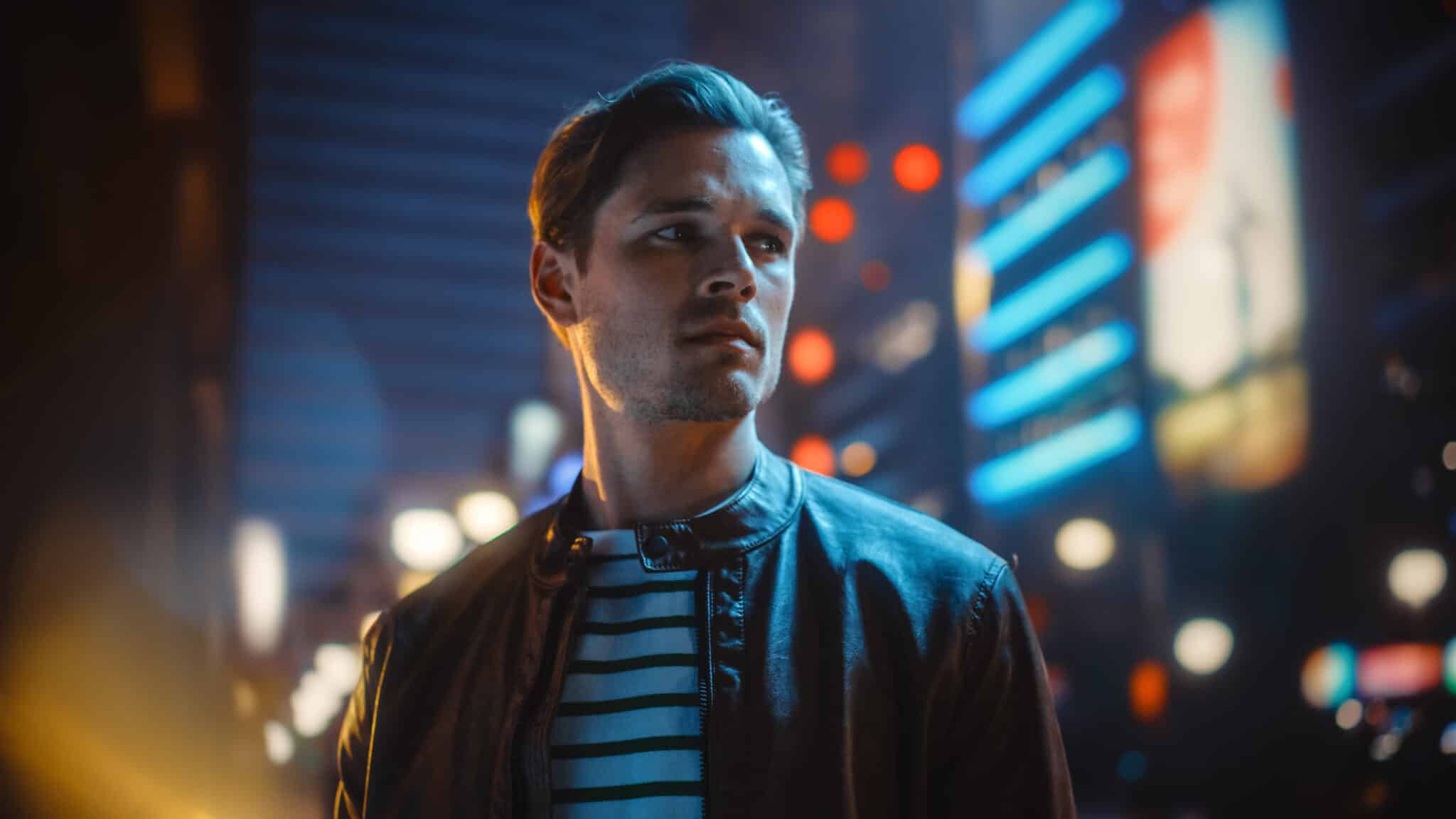 Man looking with buildings in background, cinematic marketing.