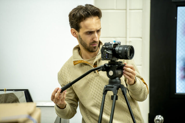 full service video production videographer adjusts camera