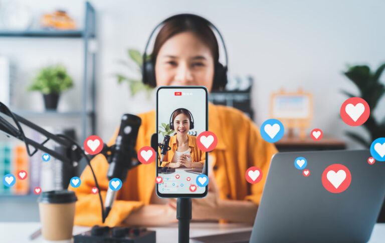 lifi media production, social media video, Vlogger live streaming podcast review on social media, Young Asian woman use microphones wear headphones with laptop record video. Content creator concept.