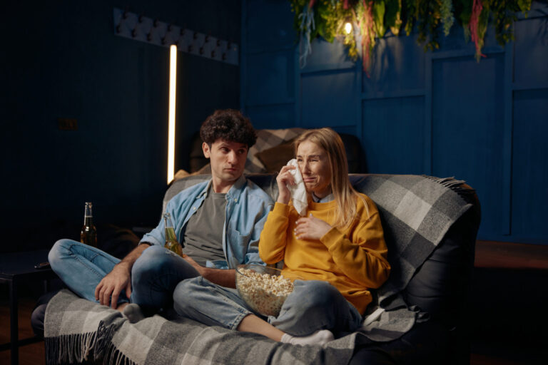 LiFi Media Production tv commercial production, Man and crying woman watching emotional film with popcorn together. Young couple in living room spending time together