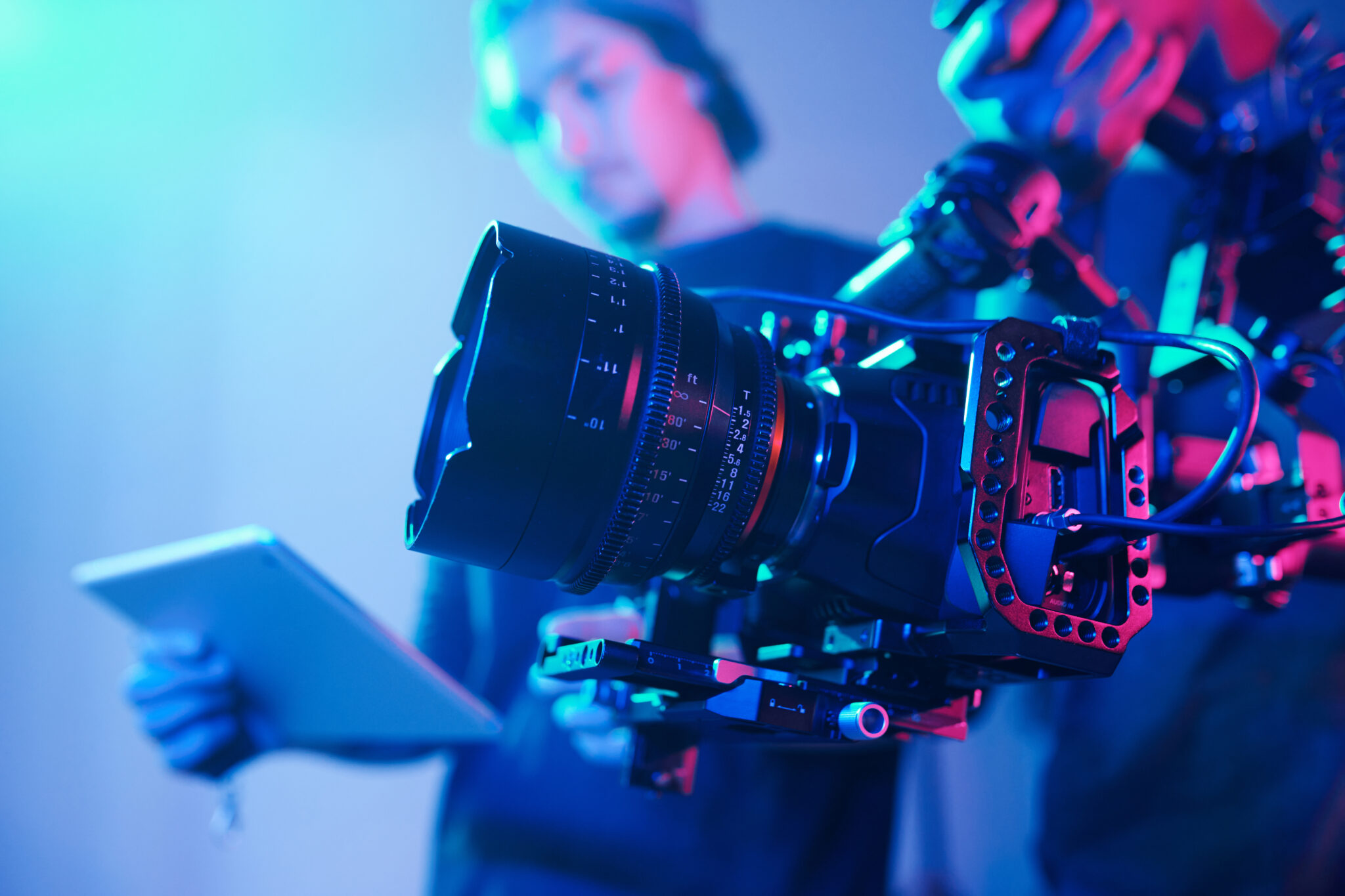 Operator using professional camera during video shoot with director overseeing the process