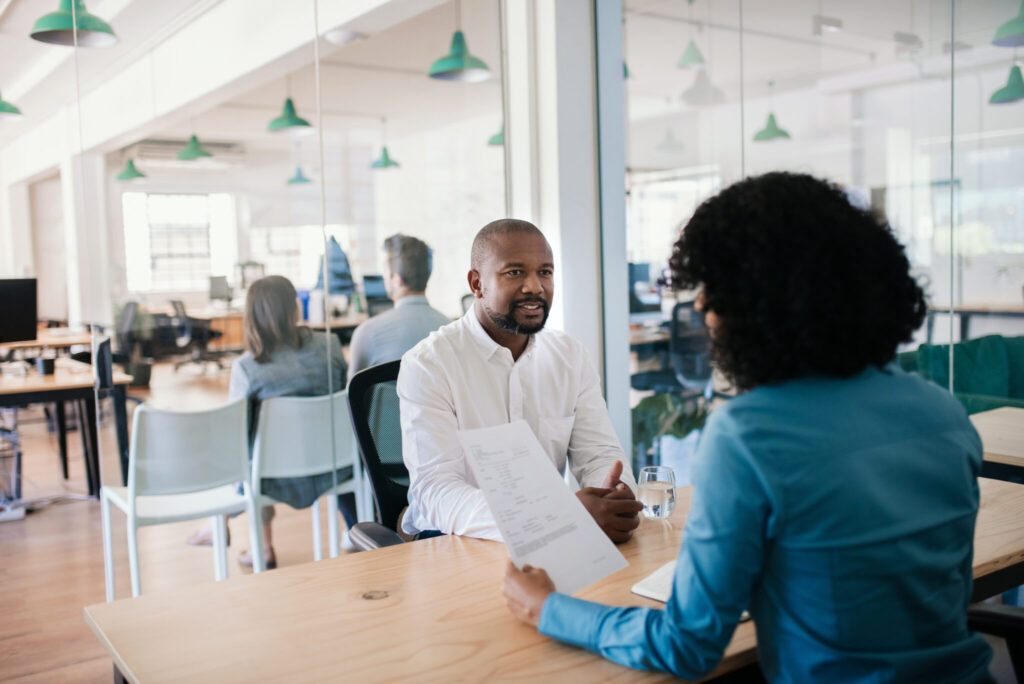 LiFi Media Production Testimonial Video Production, African American man smiling while answering questions during an interview with a manager in a modern office