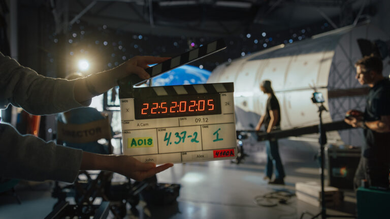 Lifi media production average cost of tv commercial production director filming ad shoot with astronaut fixing satellite actor floats on rope against digital earth backdrop behind the scenes of commercial production lifi media production new england's video production experts