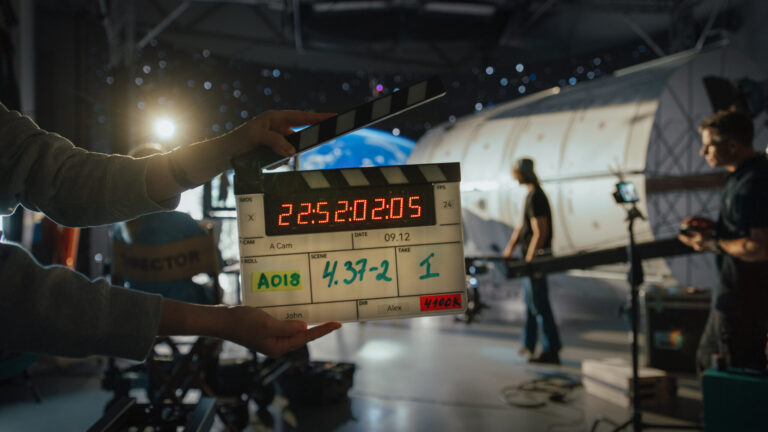 LiFi Media Production Average Cost of TV Commercial Production, director filming ad shoot with astronaut fixing satellite actor floats on rope against digital earth backdrop behind-the-scenes of commercial production