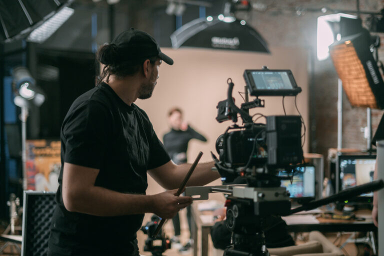 LiFi Media Production TV Commercial Production, Director of photography with a camera in his hands on the set. Professional videographer at work on filming a movie, commercial or TV series. Filming process indoors, studio