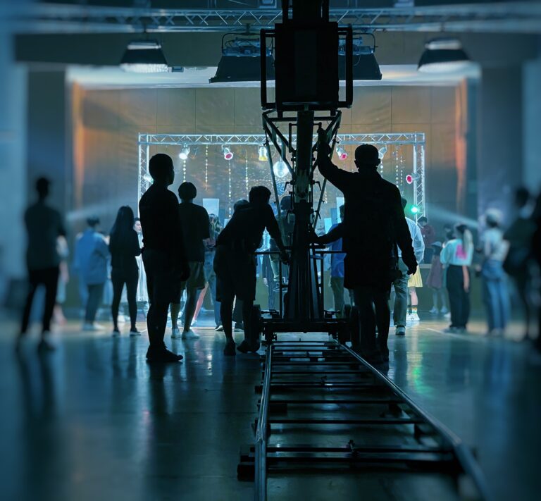 LiFi Media Production TV Commercial Production, Behind the scenes of music video shooting production crew team silhouette and camera equipment in studio. Blue filter