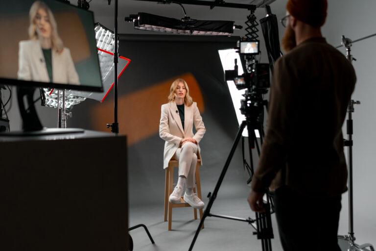 LiFi Media Production TV Commercial Production, A woman at film studio set. Behind the scenes. The room is filled with visual arts equipment, setting the stage for a tv show