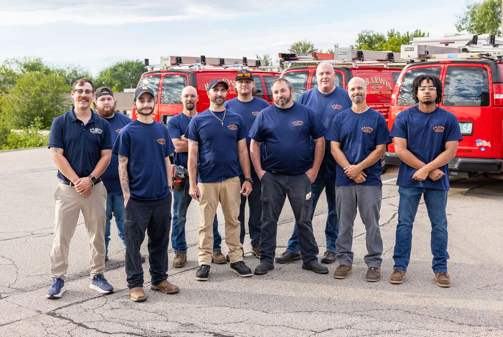 R.B. Lewis service team photographed in front of branded vehicles